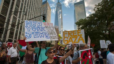 One World Trade Center is seen in the background as activists hold placards while shouting "Free, free Palestine" and "Not another nickel, not another dime, no more money for Israel's crimes," during a protest march through Lower Manhattan, New York July 24, 2014. Reuters 