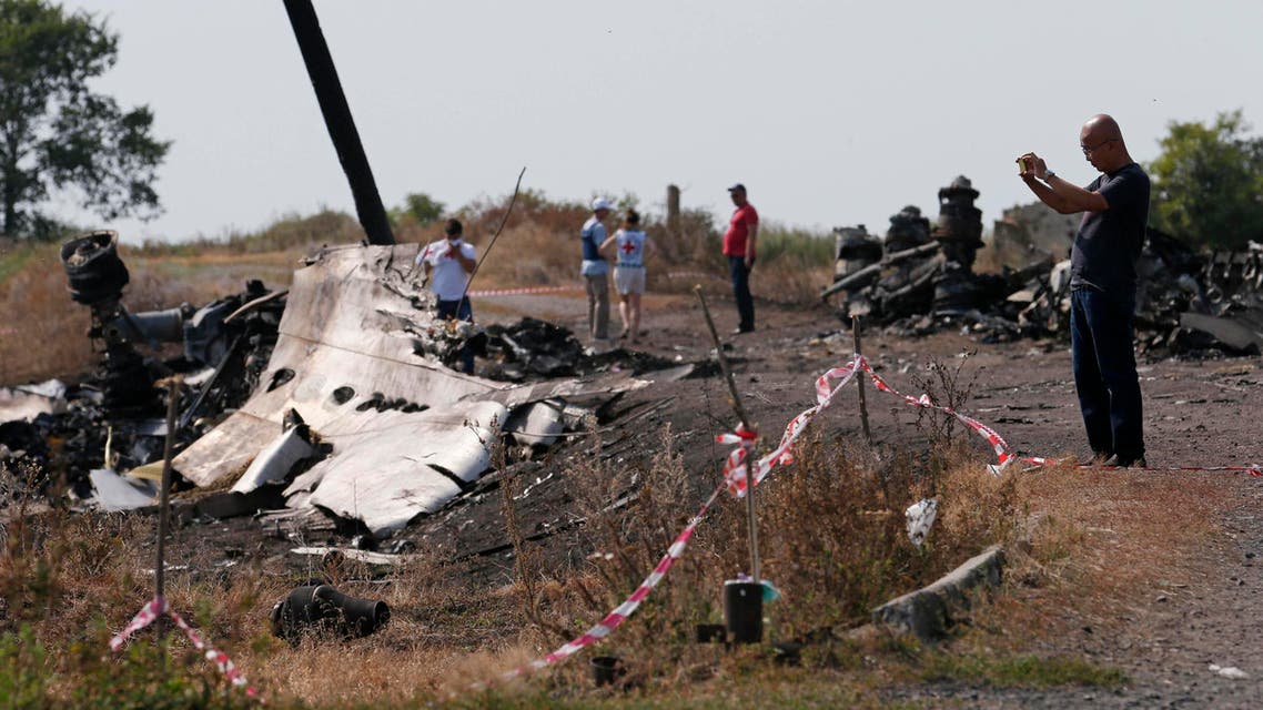 A Malaysian air crash investigator (R) works at a crash site of the Malaysia Airlines Flight MH17 near the village of Hrabove (Grabovo), Donetsk region July 24, 2014. Reuters