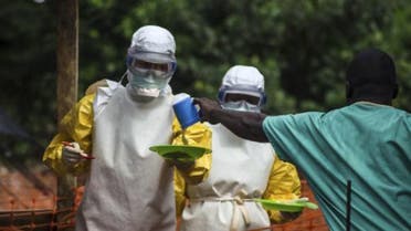 ممرضون بملابس واقية يقدمون الطعام لمريض معزول بعد اصبته بفيروس ايبولا