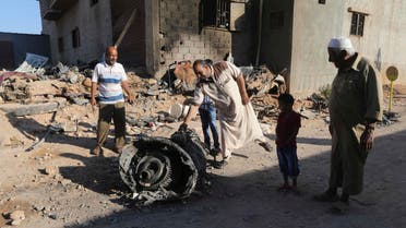 People stand next to the wreckage of a government MiG warplane which crashed during Tuesday's fighting, in Benghazi, July 29, 2014. (Reuters)