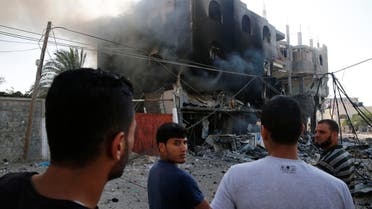 Palestinians gather near a burning building that police said was destroyed by an Israeli Air strike in Gaza City July 31, 2014. 