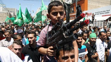 A Palestinian young boy, on his father's shoulders, holds a fake gun during a demonstration against Israel's military operation in the Gaza Strip and in support of Gaza's people on August 1, 2014. (AFP)
