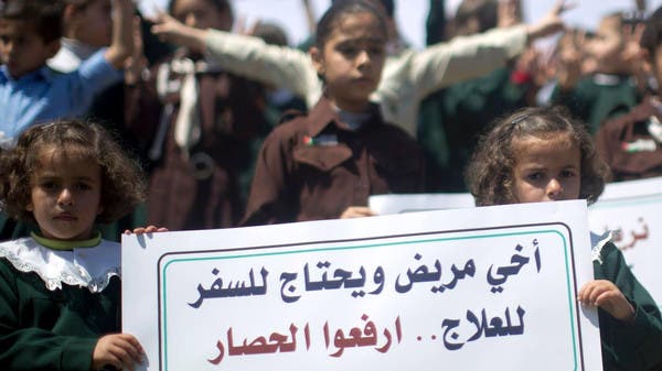 طفلتين شقيقتين ترفعن لافتة تنادي برفع الحصار عن غزة