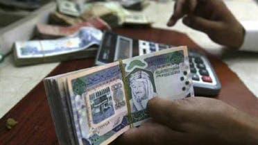 A Saudi money exchanger counts Saudi riyals in Riyadh. (Reuters)