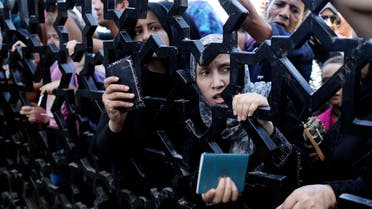 Palestinians standing behind the gate of Rafah crossing hold their passports as they try to cross into Egypt, in the southern Gaza Strip July 10, 2014. (Reuters)