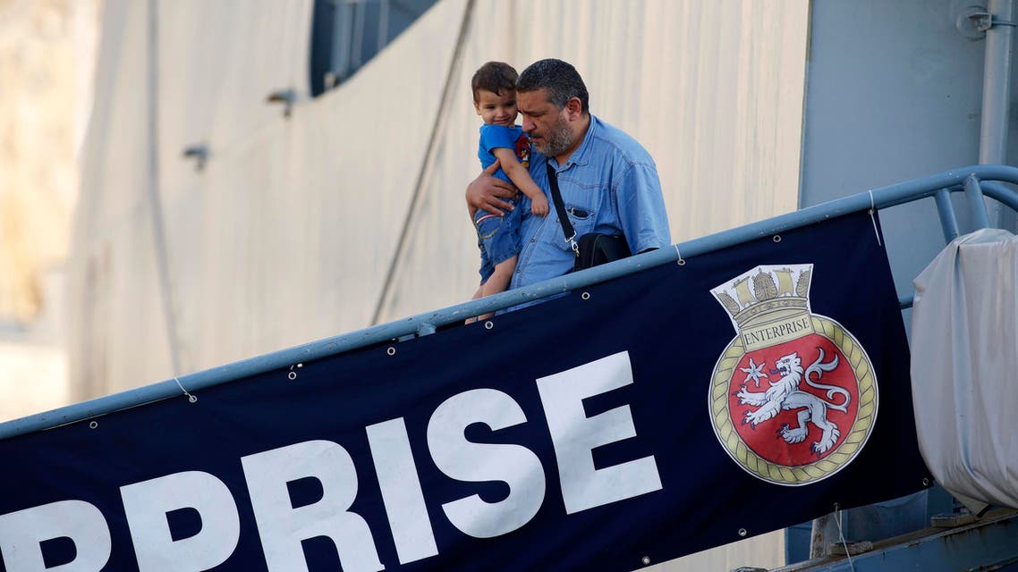 An evacuee carries his child as they disembark from the British Royal Navy ship HMS Enterprise after it arrived from Tripoli, Libya, at Valletta's Grand Harbour August 4, 2014. (Reuters)