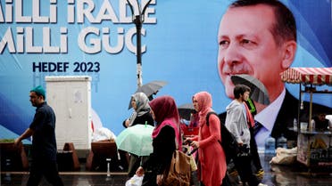 People walk past a campaign poster of Turkish Prime minister Recep Tayyip Erdogan on August 9, 2014, in Istanbul. (AFP)