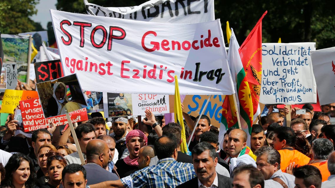 Kurds of the ethnic minority of Yazidis hold up a banner reading "Stop genocide against Yazidis in Iraq" as they march through the streets of Bielefeld August 9, 2014. (Reuters) 
