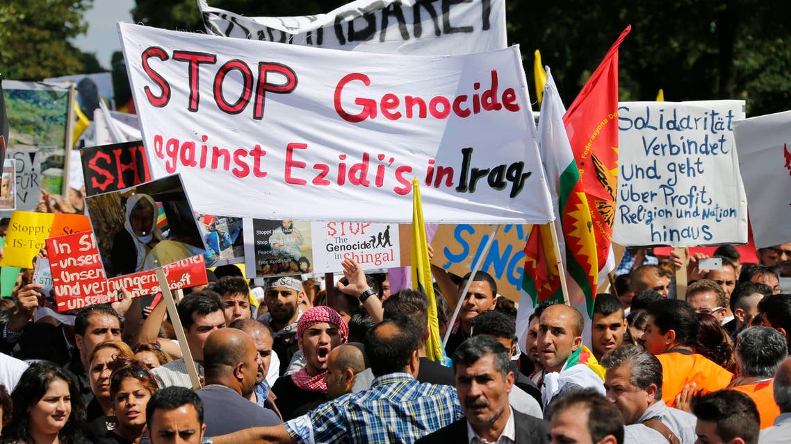 Kurds of the ethnic minority of Yazidis hold up a banner reading "Stop genocide against Yazidis in Iraq" as they march through the streets of Bielefeld August 9, 2014. (Reuters)