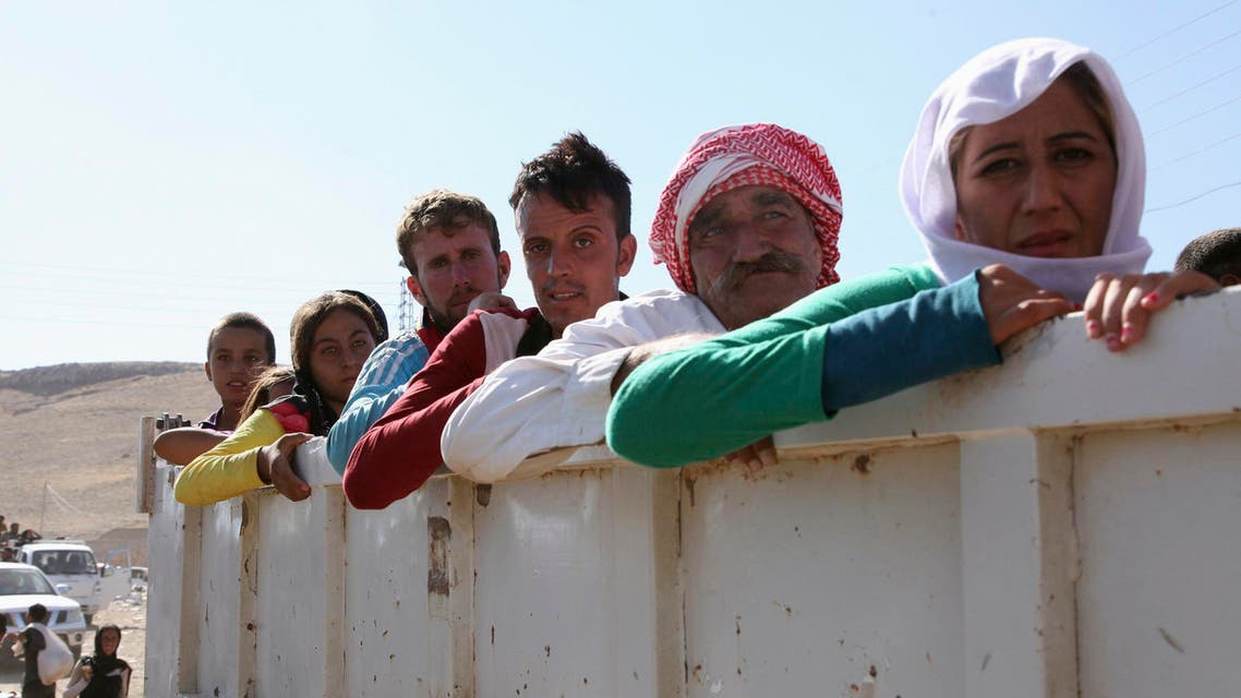 Displaced people from the minority Yazidi sect, fleeing the violence in the Iraqi town of Sinjar, re-enter Iraq from Syria at the Iraqi-Syrian border crossing in Fishkhabour, Dohuk Province, August 10, 2014. Reuters
