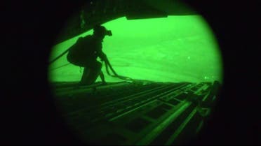 A still image captured from the U.S. Central Command night vision video footage shows an Air Force personnel retrieving straps after the U.S. military airdrop of food and water for thousands of Iraqi citizens threatened by the ISIS near Sinjar, Iraq on August 9, 2014. (Reuters)