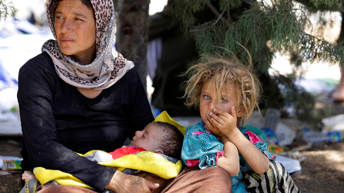 A displaced family from the minority Yazidi sect, fleeing the violence in the Iraqi town of Sinjar, waits for food while resting at the Iraqi-Syrian border crossing in Fishkhabour, Dohuk province August 13, 2014.