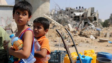 Palestinian children wait to collect water during a five-day truce in Khan Younis in the southern Gaza Strip August 14, 2014.