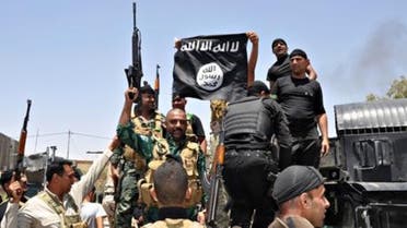 Iraqi security forces with an Isis flag captured during an operation north of Baquba. (Courtesy: of AP)