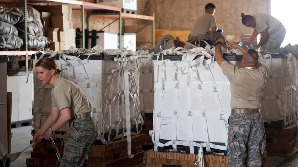 Service member volunteers push a completed pallet of food and water to prepare it for loading onto aircraft at a location in Southwest Asia in this August 11, 2014 U.S Air Force handout photo received August 12, 2014. (Reuters)