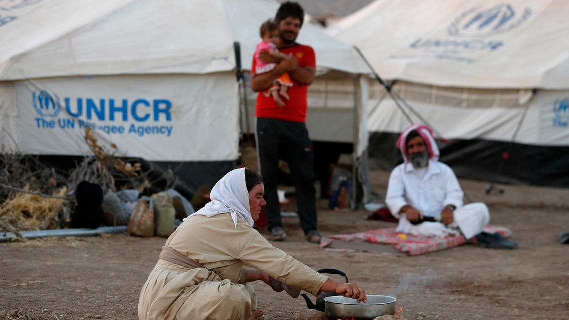 Displaced people from the minority Yazidi sect, who fled the violence in the Iraqi town of Sinjar, sit on the ground at Bajed Kadal refugee camp south west of Dohuk province August 15, 2014. (Reuters)