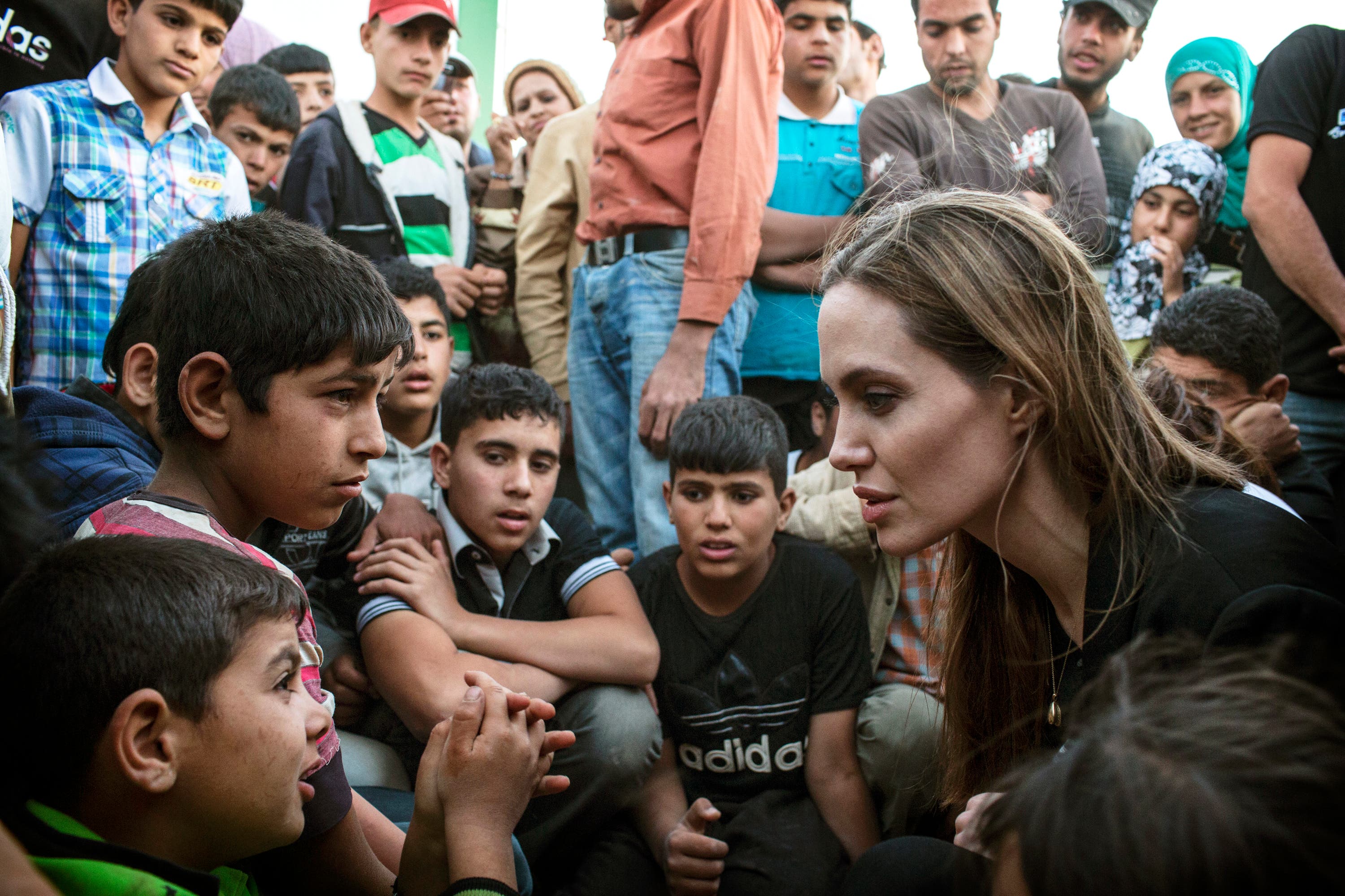 Photo released by the UNHCR shows special envoy Angelina Jolie, right, speaking with Syrian refugees in a Jordanian military camp based near the Syria-Jordan border on June 18, 2013. (Photo courtesy: AP) 