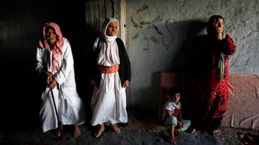Displaced people from the minority Yazidi sect who fled the violence in the Iraqi town of Sinjar, wait for aid at an abandoned building that they are using as their main residence, outside the city of Dohuk August 25, 2014. (Reuters)