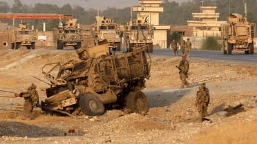 U.S. troops assess the damage to an armoured vehicle of NATO-led International Security Assistance force (ISAF) at the site of a suicide attack in Jalalabad province, August 24, 2014. (Reuters)