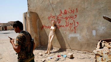 A Kurdish Peshmerga fighter walks past a mannequin leaning on the wall of the former headquarters of Islamic State militants in Sulaiman Pek, after the town was recaptured this week, September 3, 2014. (Reuters)