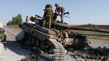 Ukrainian soldiers inspect a damaged tank on the outskirts of the southern coastal town of Mariupol, September 6, 2014. d