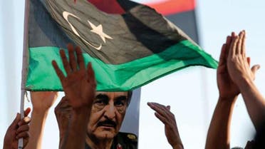 A picture of General Khalifa Haftar is seen next to a Libyan flag during a demonstration in Benghazi. Photo: Esam Omran Al-Fetori/Reuters