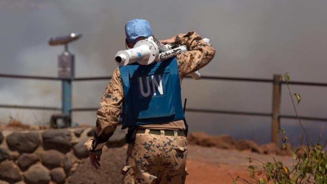 A UN peacekeeper carries equipment at the Syrian-Israeli border.