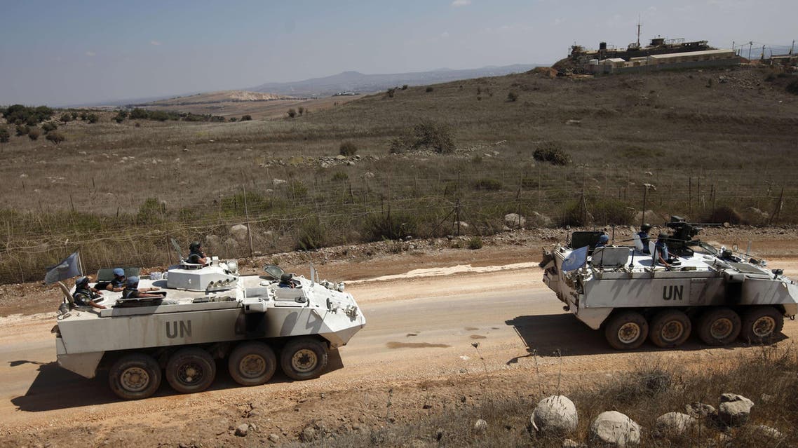 United Nations Disengagement Observer Force (UNDOF) armoured personnel carriers, including an armed one (R), escort a convoy of UNDOF vehicles leaving the Syrian side of the Golan Heights, on September 15, 2014. (AFP)