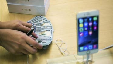 An employee counts money while selling new iPhone 6 phones at the Fifth Avenue Apple store on the first day of sales in Manhattan, New York Sept. 19, 2014. (Reuters)