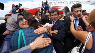 Turkish Consul General of Mosul Ozturk Yilmaz (2nd R) is welcomed by his relatives as Turkish Prime Minister Ahmet Davutoglu (C) looks on, as they arrive at Esenboga airport in Ankara September 20, 2014. (Reuters)