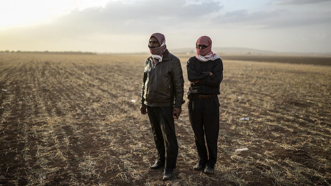Syrian Kurdish men stand near the Syrian border at Suruc in Sanliurfa province, on Sept. 25, 2014. (AFP)