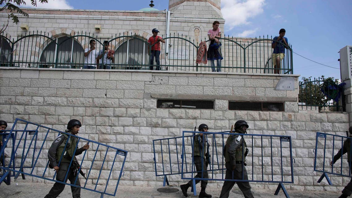 Israeli border policemen carry security barriers before Palestinian Muslim worshippers perform traditional Friday prayers in the Arab east Jerusalem neighbourhood of Ras al-Amud September 26, 2014. (Reuters)