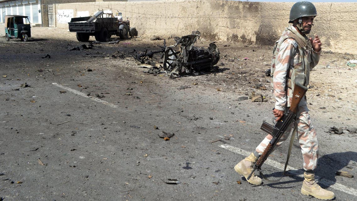 A Pakistani security personnel walks past a destroyed vehicle after a bomb blast in Quetta on October 4, 2014. (Reuters)