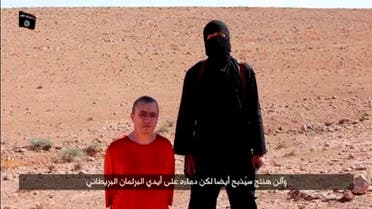 A masked man stands next to a kneeling man identified as British citizen Alan Henning (L), in this still image taken from video released by Islamic State militants fighting in Iraq and Syria, on October 3, 2014. 