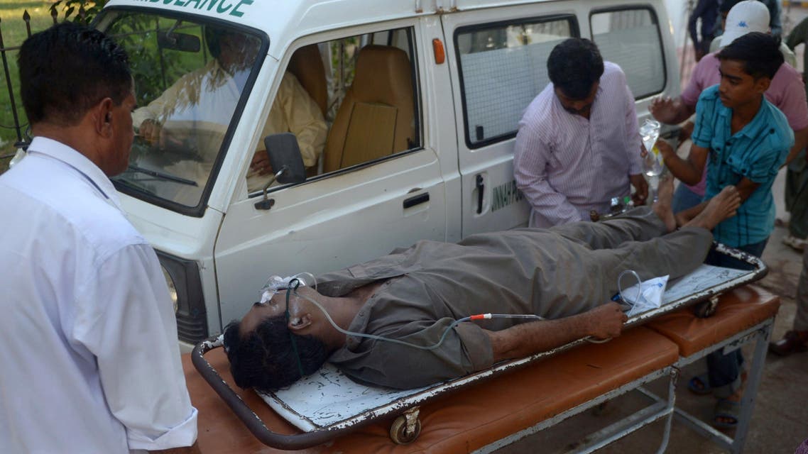 Pakistani paramedics shift a liquor victim to a hospital in Karachi on Oct. 8, 2014. (AFP)