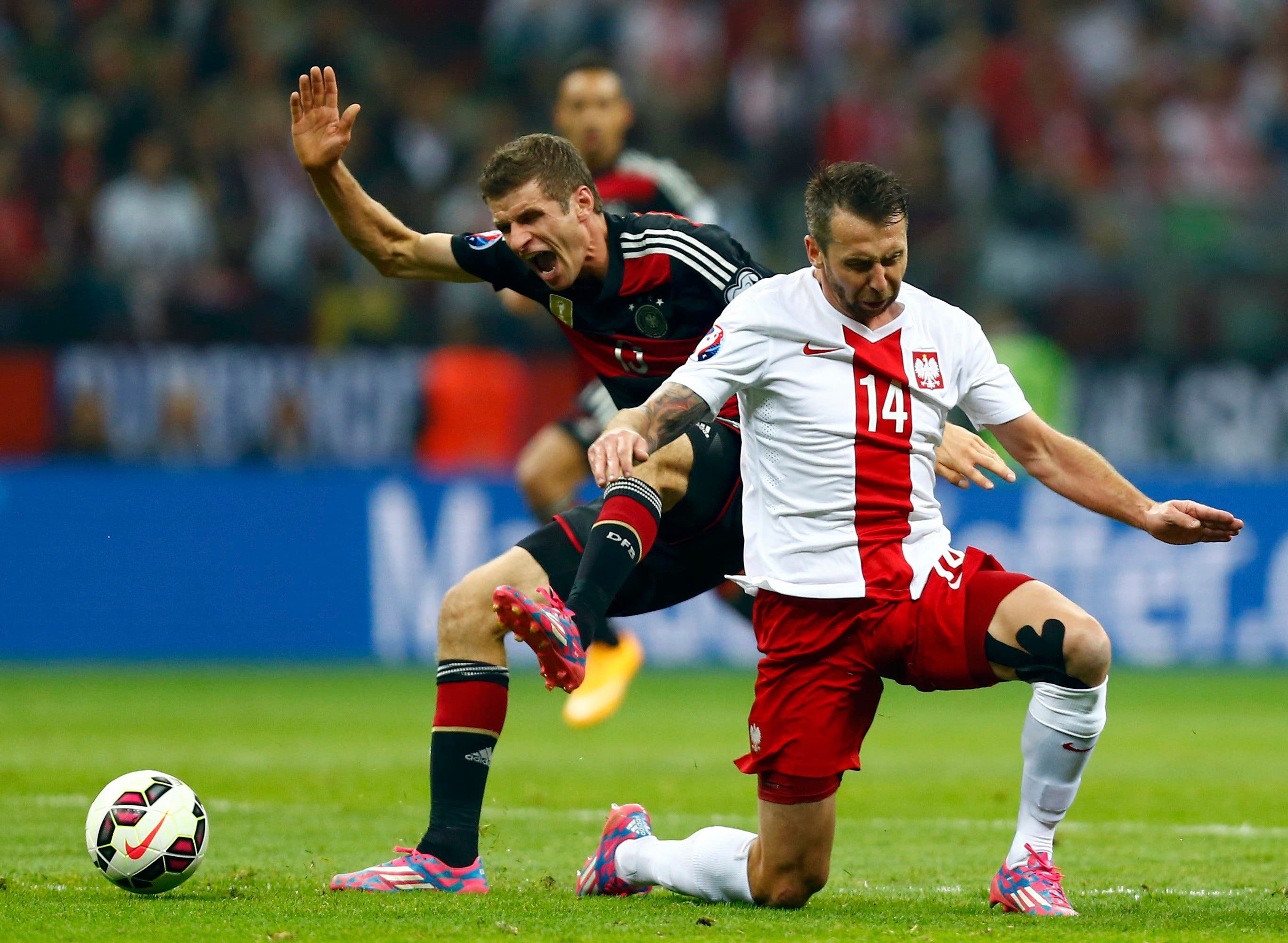 Germany's Thomas Mueller (L) challenges Poland's Jakub Wawrzyniak during their Euro 2016 group D qualifying soccer match at the National stadium in Warsaw October 11, 2014. (Reuters)
