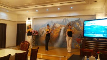 2- Dancers at the restaurant singing 'You are my superstar' with the aid of a karoke machine. All Okryu-gwan staff wear small North Korean flags pinned to their uniforms. (Al Arabiya)