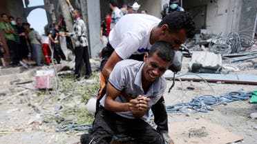 A Palestinian reacts after his mother's body was removed from the rubble of their house which witnesses said was destroyed by an Israeli air strike, in Rafah, southern Gaza in this August 4, 2014 file photo. 