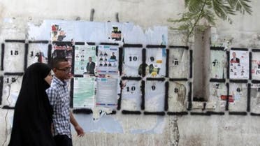 People walk past posters for parliamentary elections in Tunis(Reuters)