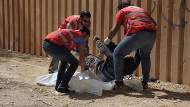 Members of the Libyan Red Crescent remove the body of a man from the street during clashes between soldiers and Islamists who control Benghazion Oct. 15, 2014. (AFP)  