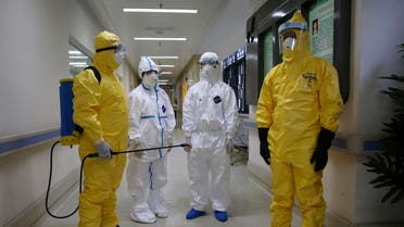 Health workers in protection suits wait in the corridor near a quarantine ward during a drill to demonstrate the procedures of handling Ebola victims, at a hospital in Guangzhou, Guangdong province October 16, 2014. (Reuters)
