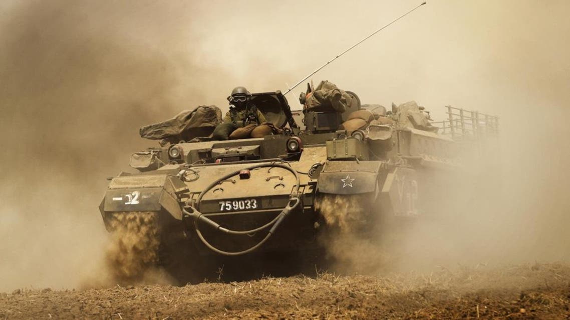 An Israeli soldier from the Nahal Infantry Brigade gestures on top of an armoured personnel carrier across a field near central Gaza Strip. (File photo: Reuters)