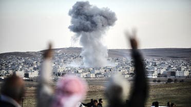  A picture taken from the southeastern Turkish village of Mursitpinar in the province of Sanliurfa shows people gesturing as smoke rises in the sky following an attack by jet aircrafts in the Syrian town of Kobane, also known as Ain al-Arab, on October 22, 2014. AFP