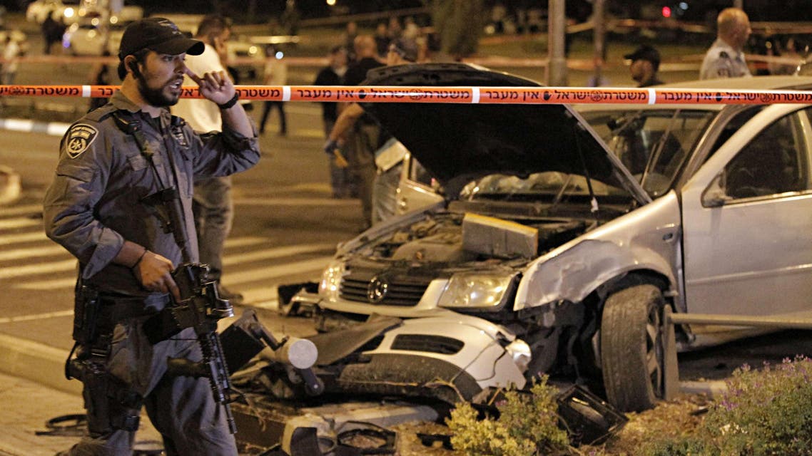 Israeli policemen stand guard at the scene after a car rammed a group of pedestrians at the Ammunition Hill tram stop, which lies on the seamline between west and occupied east Jerusalem, injuring nine on Oct. 22, 2014. (AFP)
