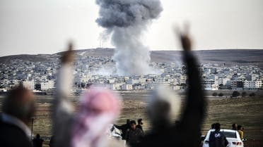 eople gesturing as smoke rises in the sky following an attack by jet aircrafts in the Syrian town of Kobane, also known as Ain al-Arab, on Oct. 22, 2014.  (AFP)