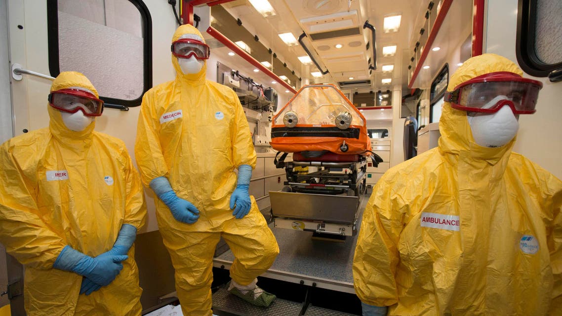 Staff of the emergency medical services in France (SAMU) dressed in Ebola virus protections outfits stand near a stretcher placed inside an ambulance at the Necker Hospital in Paris, October 24, 2014. (Reuters)