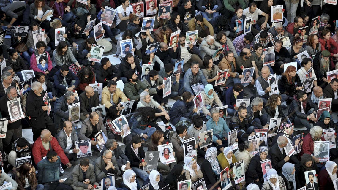 People hold pictures of disappeared people on October 25, 2014 as they gather on Istiklal avenue in Istanbul. AFP