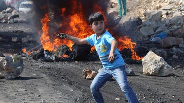 A Palestinian boy uses a sling to throw stones towards Israeli soldiers during clashes following a protest against the near-by Jewish settlement of Qadomem, in the West Bank village of Kofr Qadom near Nablus October 24, 2014. (File photo:Reuters)