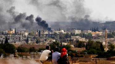 Kurdish refugees from Kobani watch as thick smoke covers the Syrian town of Kobane, October 26, 2014. (Reuters)
