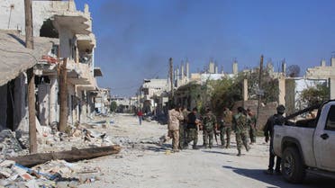 Smoke rises as forces loyal to Syria's President Bashar al-Assad gather along a damaged street in the town of Morek after regaining control of the area October 24, 2014. (Reuters)